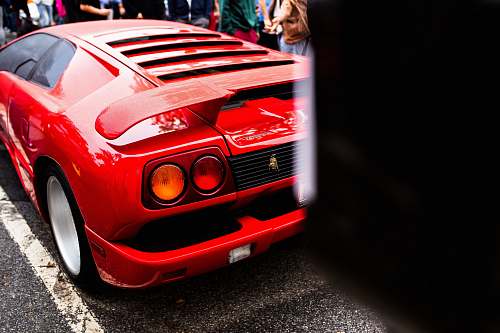 sports car red luxury car parked on concrete road automobile